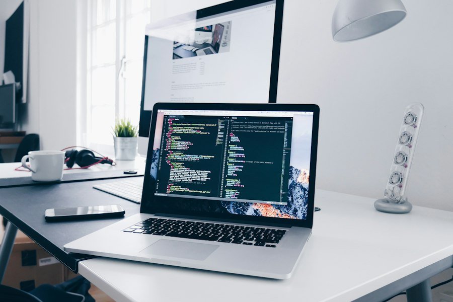 Laptop showing website code on a designer's desk